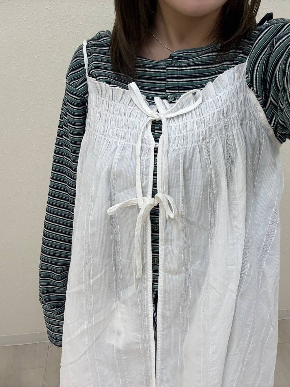 レッド系のパンプス、ブルー系のデニムパンツ、ホワイト系のワンピースを着用したレディースの春コーディネートの1枚目の写真