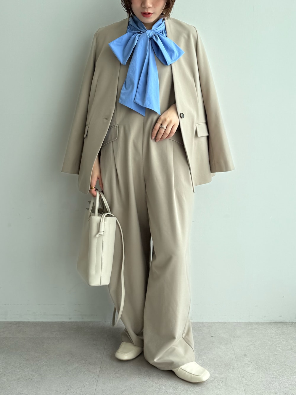 ブルー系のシャツ/ブラウス、ベージュ系のつなぎ/オールインワン、ベージュ系のノーカラージャケットを着用したレディースの秋コーディネートの1枚目の写真