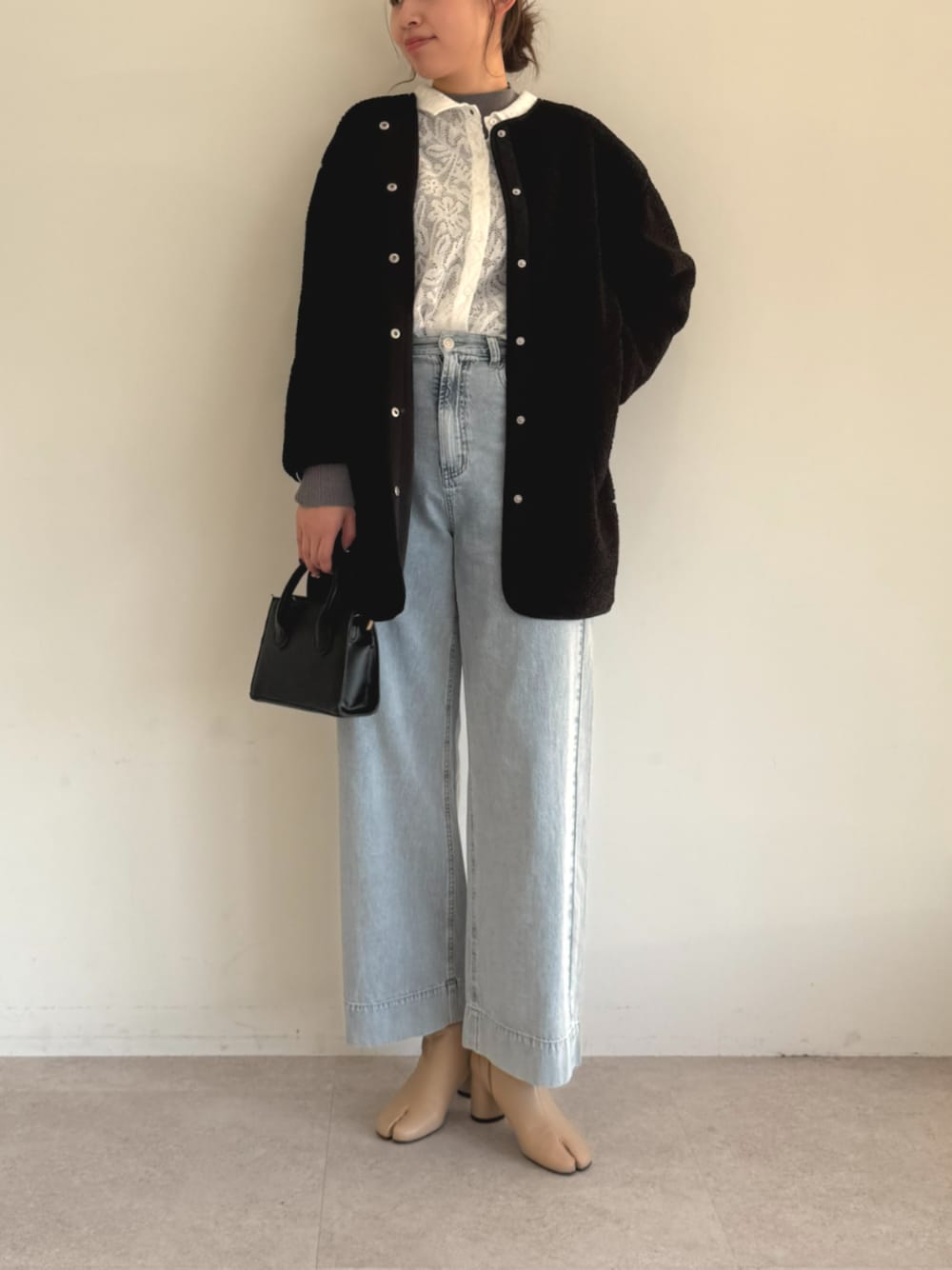 ホワイト系のカーディガン/ボレロ、ブルー系のデニムパンツ、グレー系のノーカラーコートを着用したレディースの秋コーディネートの1枚目の写真