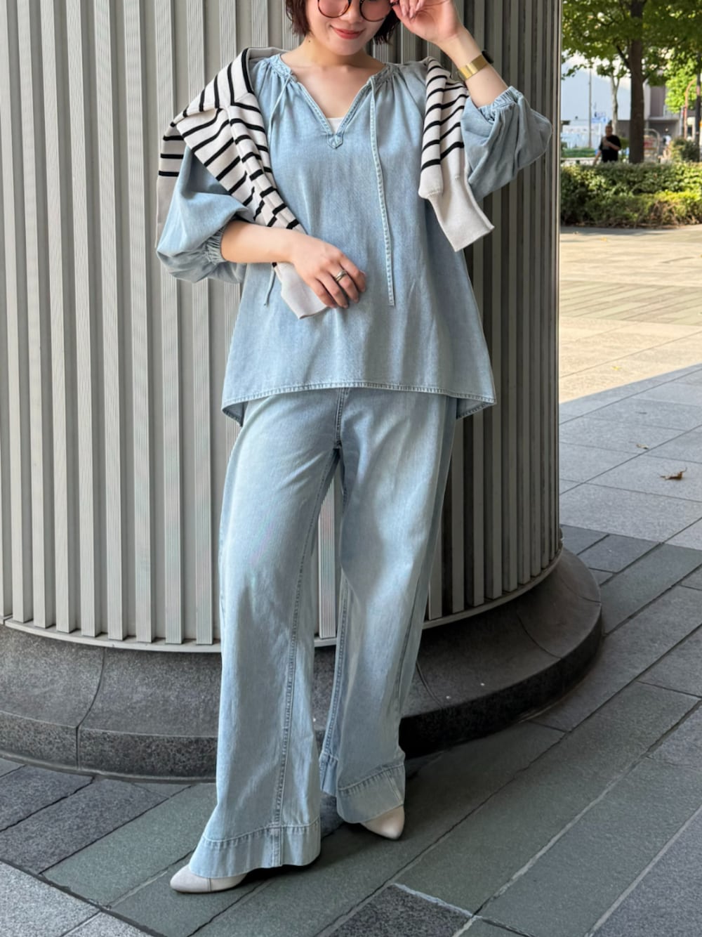 ブルー系のシャツ/ブラウス、ブルー系のデニムパンツ、ホワイト系のニット/セーターを着用したレディースの秋コーディネートの1枚目の写真