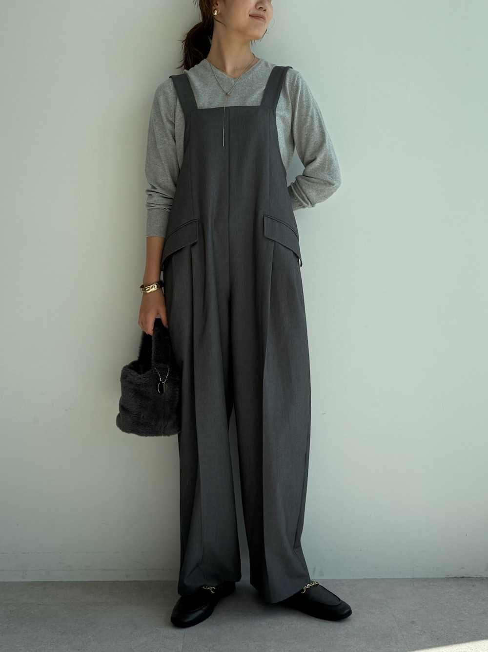 グレー系のつなぎ/オールインワン、グレー系のニット/セーターを着用したレディースの秋コーディネートの1枚目の写真