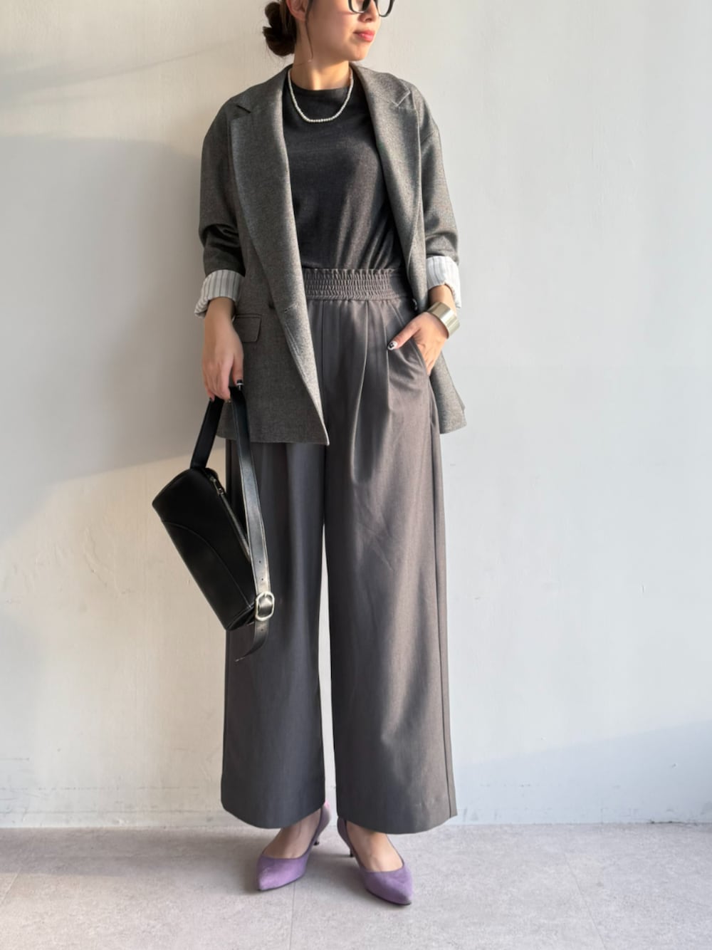 グレー系のスラックス、グレー系のニット/セーター、グレー系のテーラードジャケットを着用したレディースの秋コーディネートの1枚目の写真