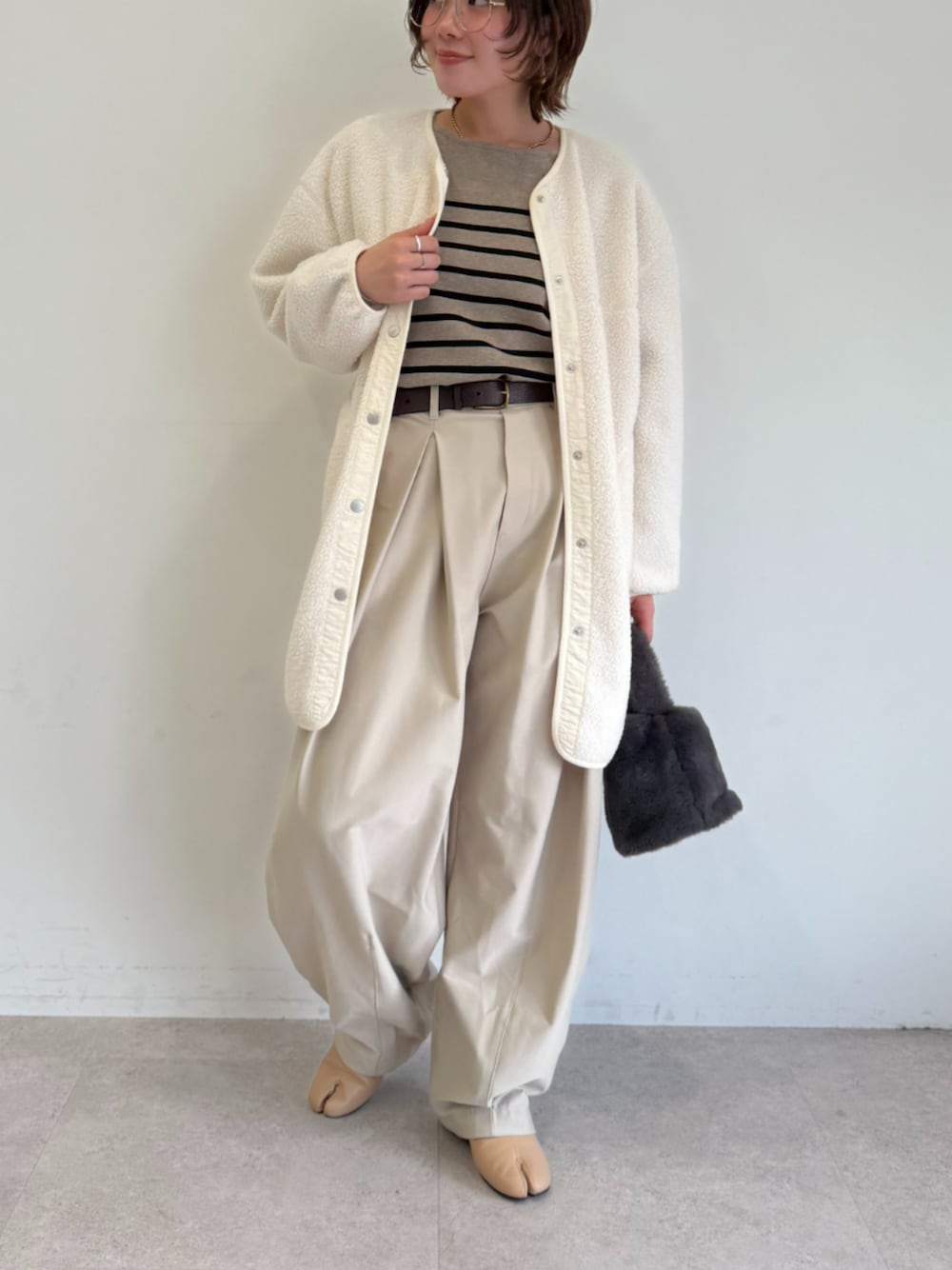 ベージュ系のその他パンツ、ホワイト系のノーカラーコート、ブラウン系のニット/セーターを着用したレディースの秋コーディネートの1枚目の写真