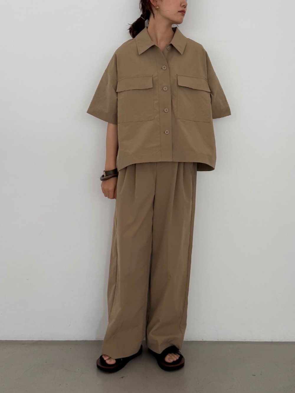 ベージュ系のチノパンツ、ベージュ系のシャツ/ブラウスを着用したレディースの夏コーディネートの1枚目の写真