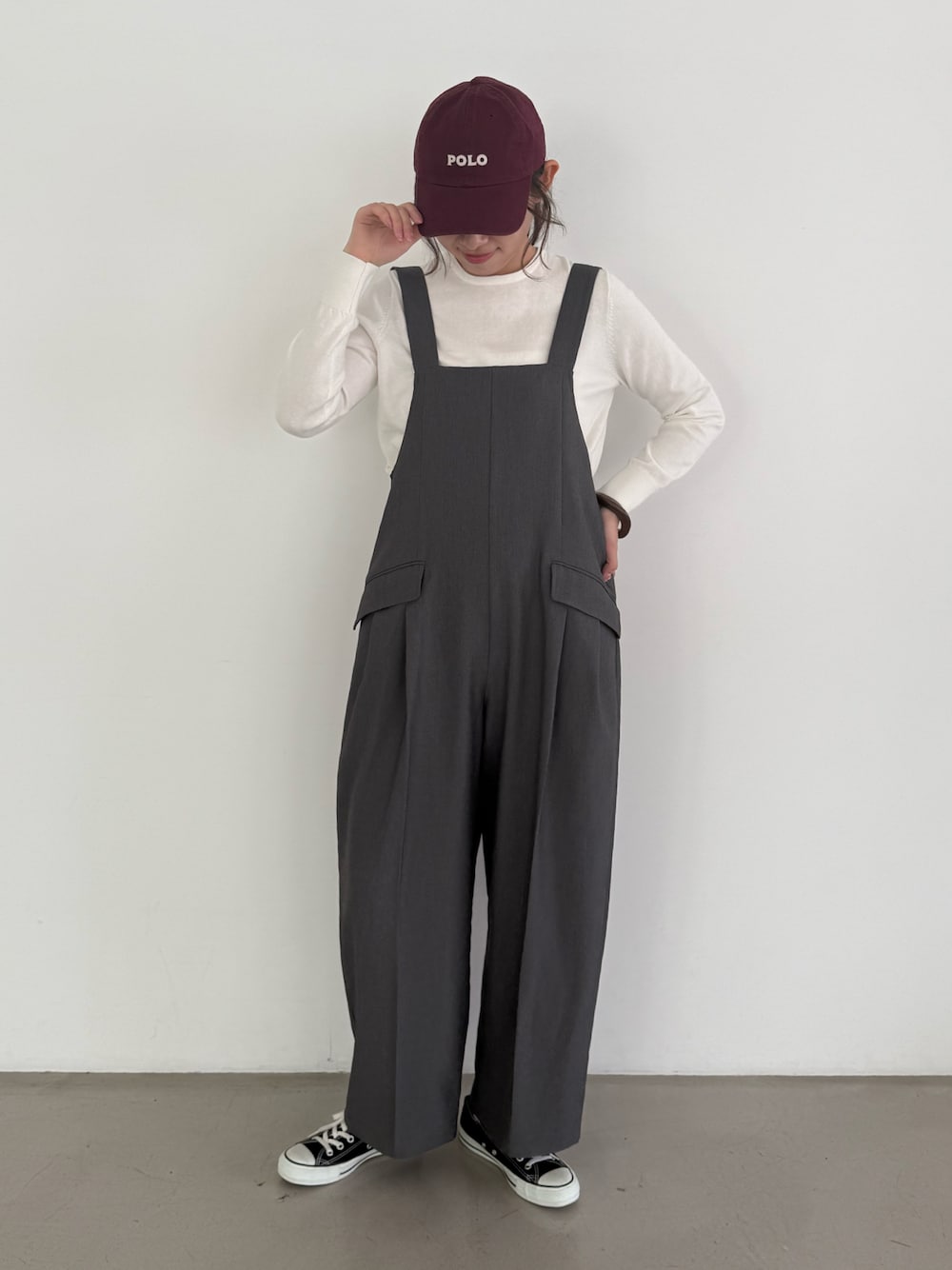 グレー系のつなぎ/オールインワン、ホワイト系のニット/セーターを着用したレディースの秋コーディネートの1枚目の写真