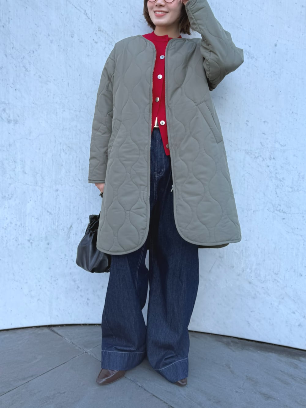 ブルー系のデニムパンツ、グリーン系のその他アウター、レッド系のニット/セーターを着用したレディースの秋コーディネートの1枚目の写真