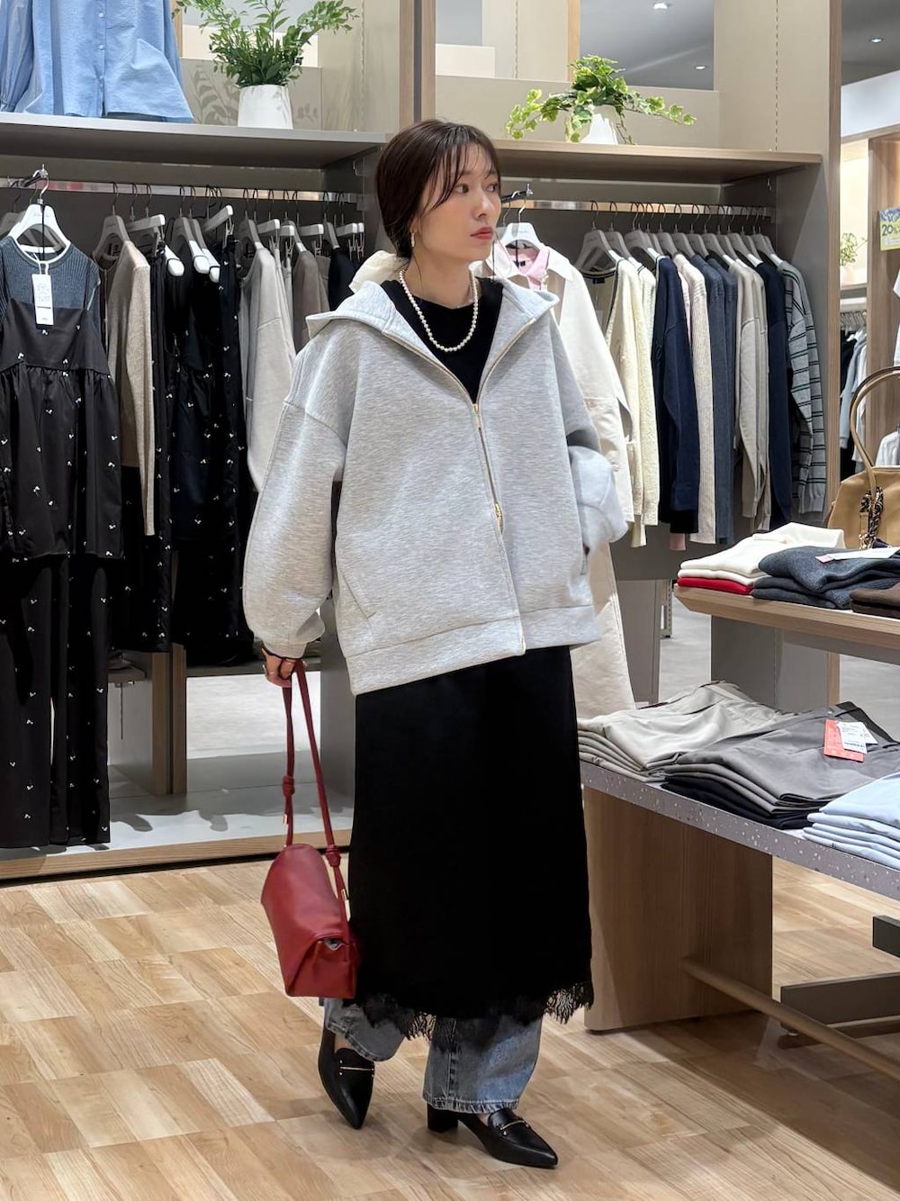 レッド系のショルダーバッグ、ブラック系のTシャツ/カットソー、ブルー系のデニムパンツを着用したレディースの春コーディネートの1枚目の写真