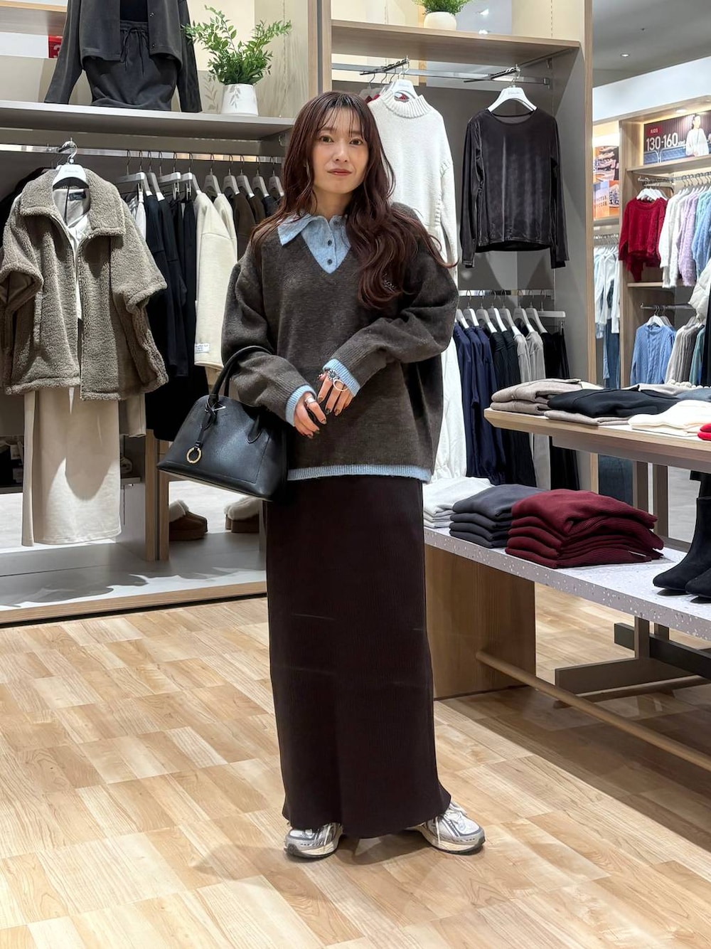 ブラック系のショルダーバッグ、ブラウン系のワンピースを着用したレディースの秋コーディネートの1枚目の写真