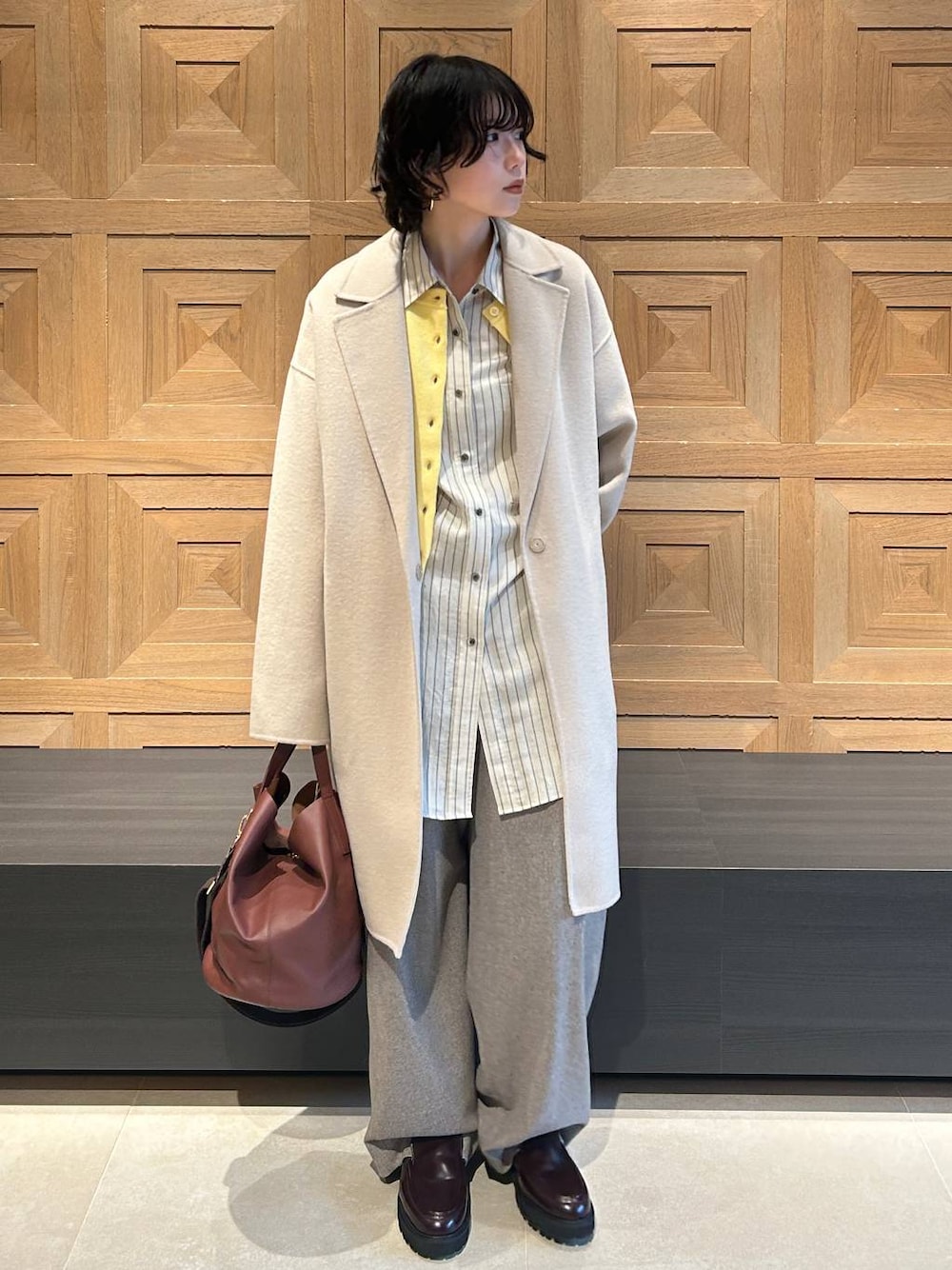 ブラウン系のショルダーバッグ、ベージュ系のその他パンツ、ホワイト系のシャツ/ブラウスを着用したレディースの秋コーディネートの1枚目の写真