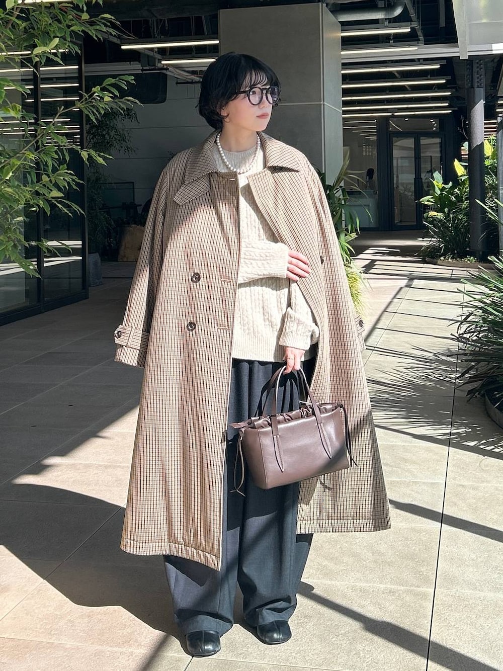 ベージュ系のチェスターコート、ホワイト系のニット/セーター、グレー系のその他パンツを着用したレディースの秋コーディネートの1枚目の写真