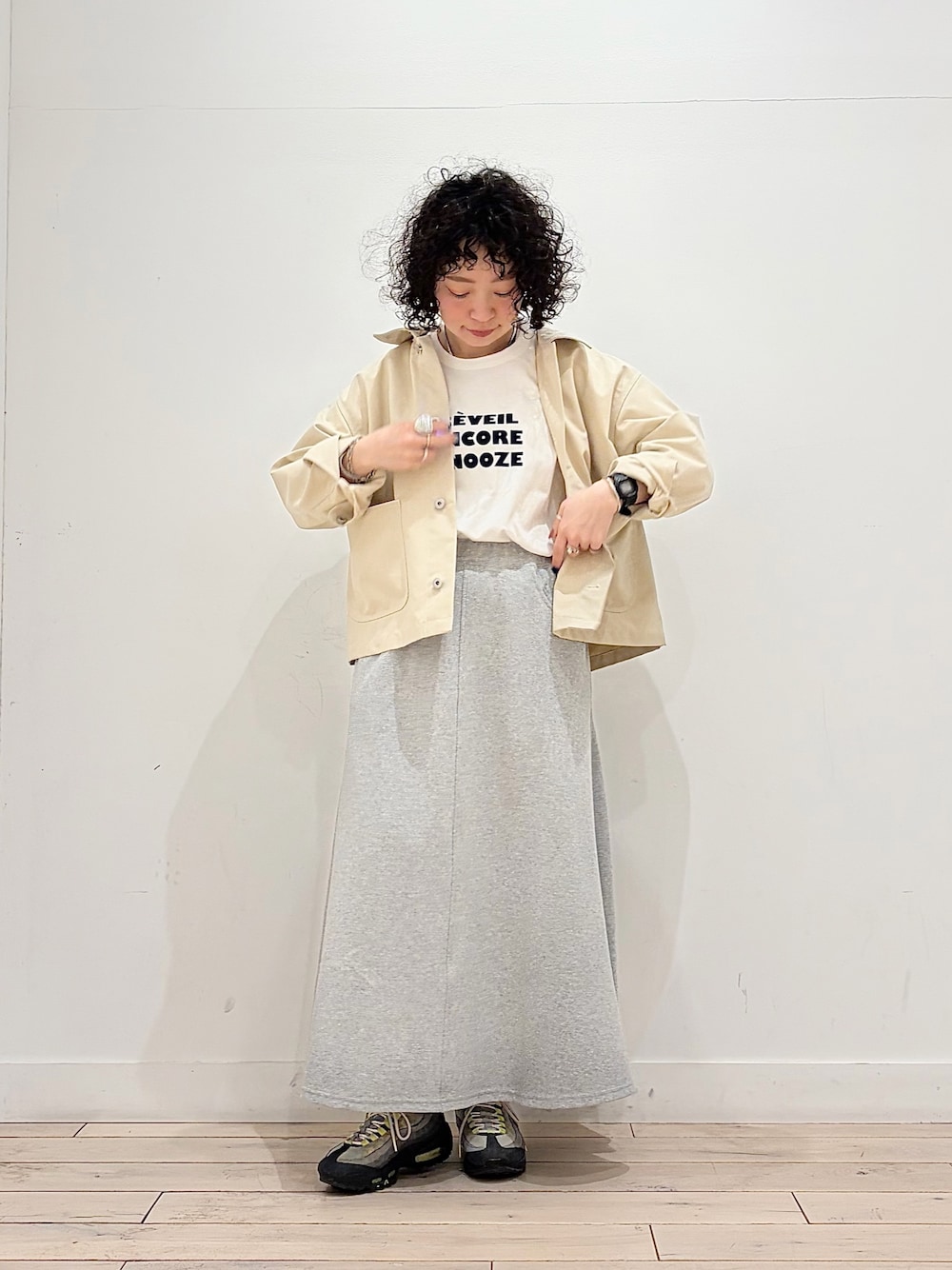 グレー系のスカート、その他のTシャツ/カットソー、ホワイト系のカバーオールを着用したレディースの春コーディネートの1枚目の写真