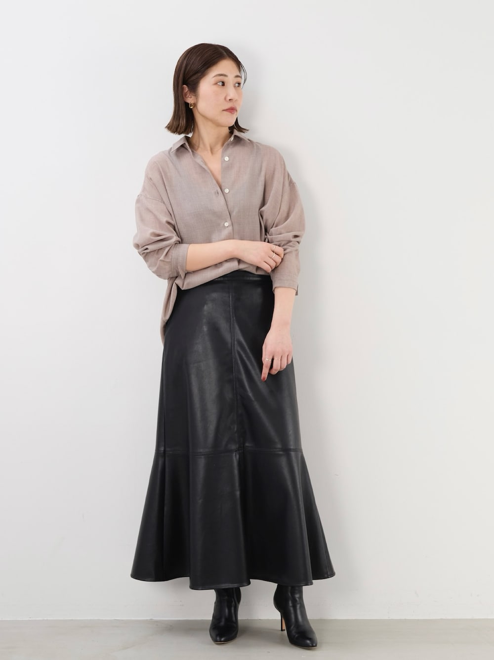 ブラック系のスカート、ベージュ系のシャツ/ブラウスを着用したレディースの秋コーディネートの1枚目の写真
