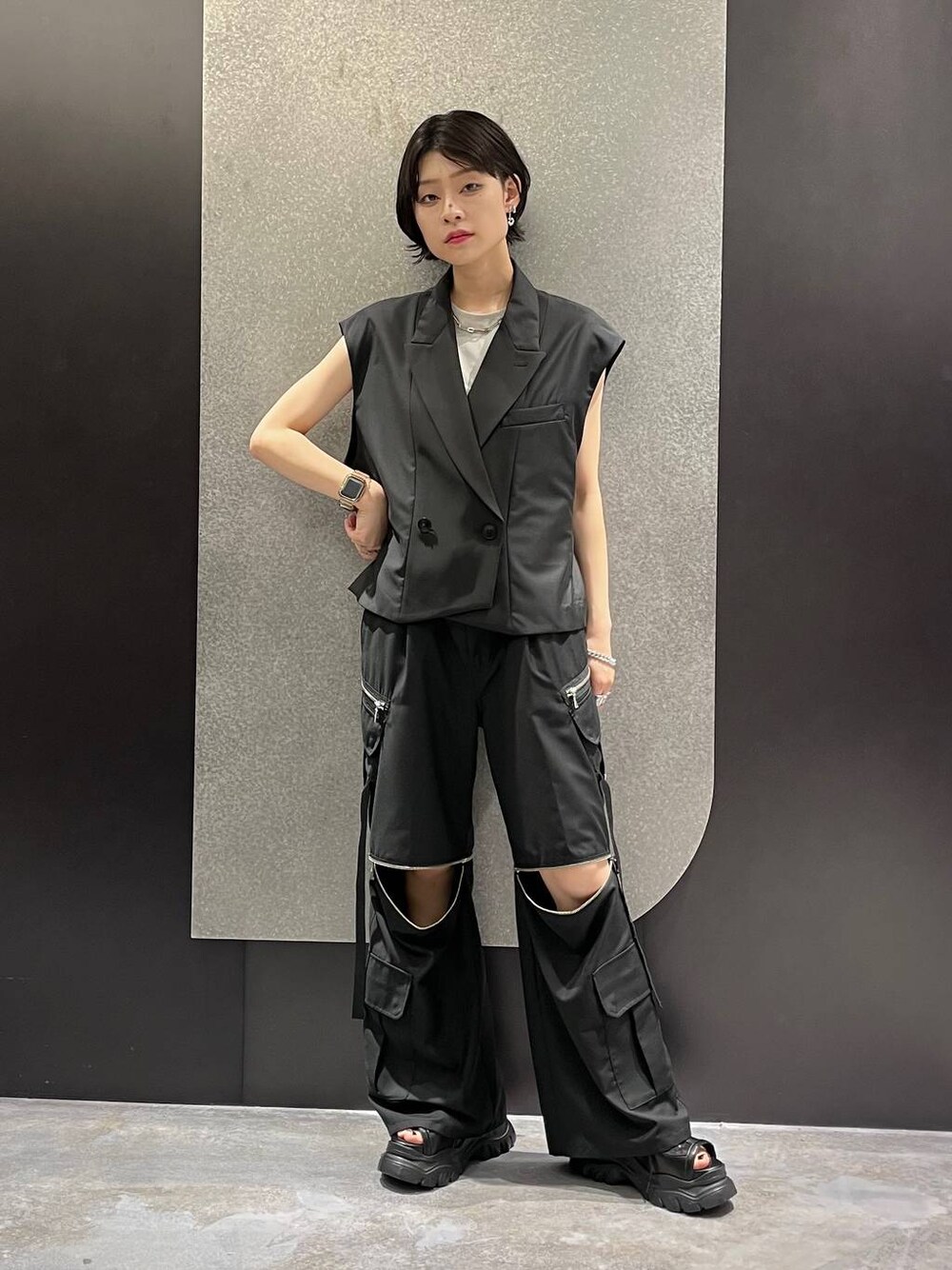 ブラック系のベスト、グレー系のTシャツ/カットソー、ブラック系のカーゴパンツを着用したレディースの夏コーディネートの1枚目の写真