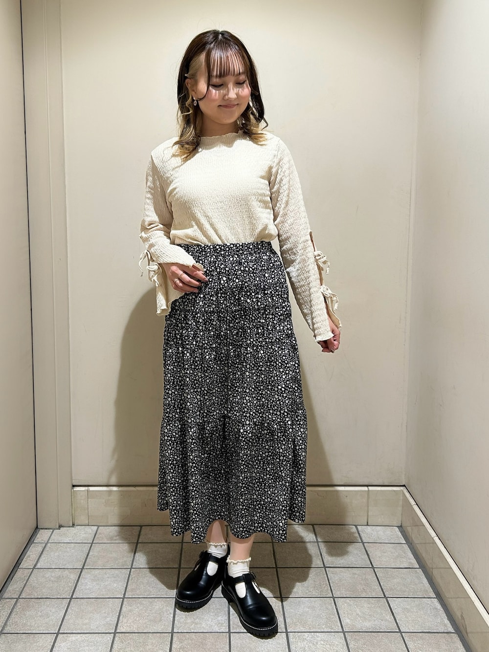 ホワイト系のTシャツ/カットソー、グレー系のスカート、ブラック系のその他シューズを着用したレディースの春コーディネートの1枚目の写真