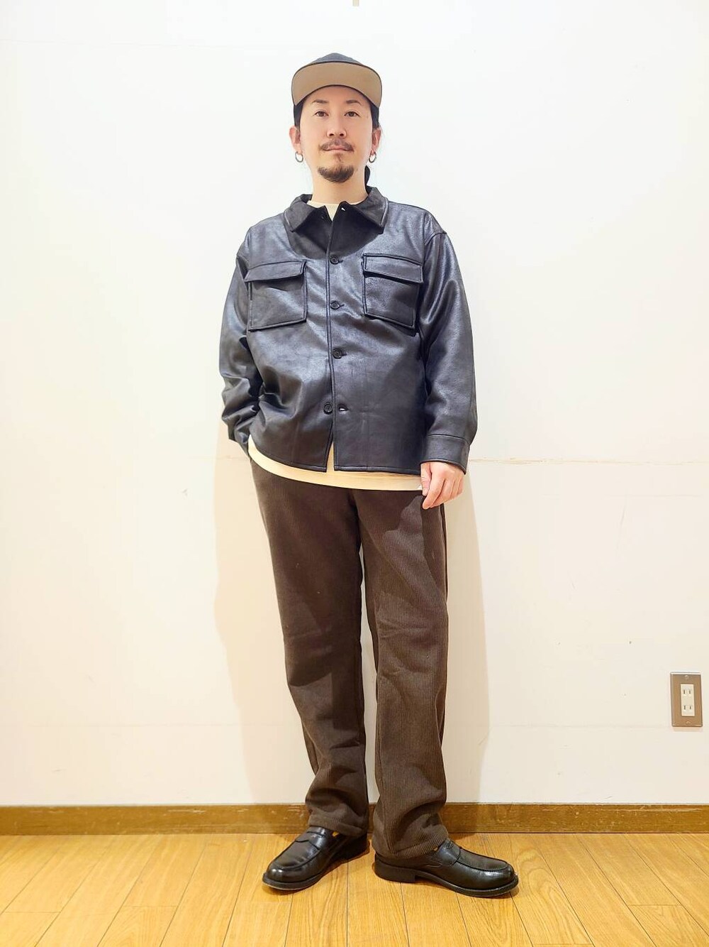 ブラック系のブルゾン、ブラウン系のその他パンツ、ホワイト系のTシャツ/カットソーを着用したメンズの冬コーディネートの1枚目の写真