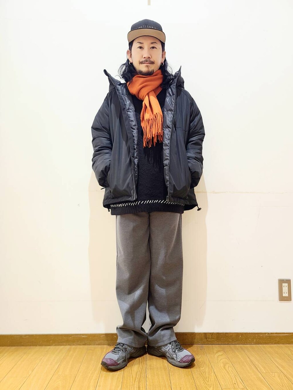 グレー系のその他パンツ、ブラック系のニット/セーター、ブラック系のダウンジャケット/コートを着用したメンズの冬コーディネートの1枚目の写真