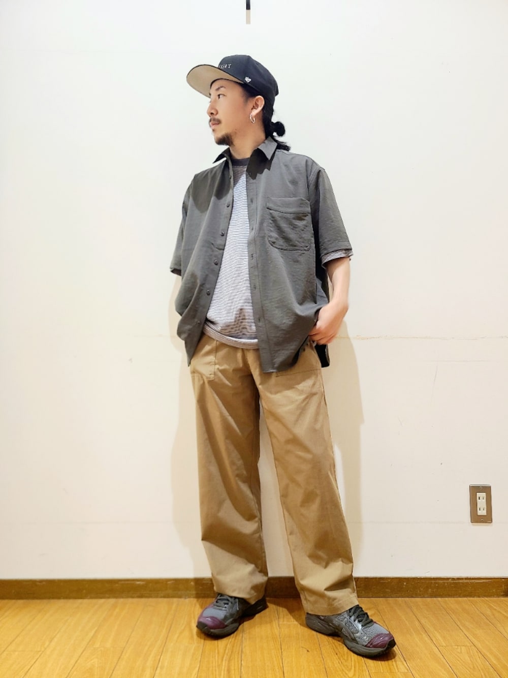 グレー系のシャツ/ブラウス、グリーン系のチノパンツ、ブラック系のキャップを着用したメンズの夏コーディネートの1枚目の写真