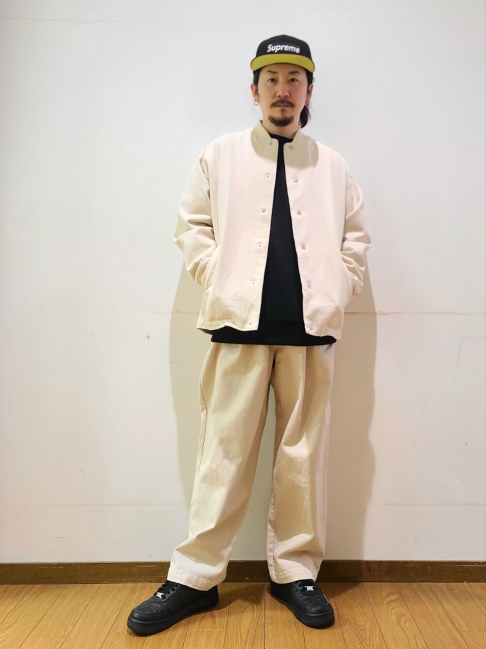 ブラック系のスウェット、ホワイト系のデニムパンツを着用したメンズの冬コーディネートの1枚目の写真