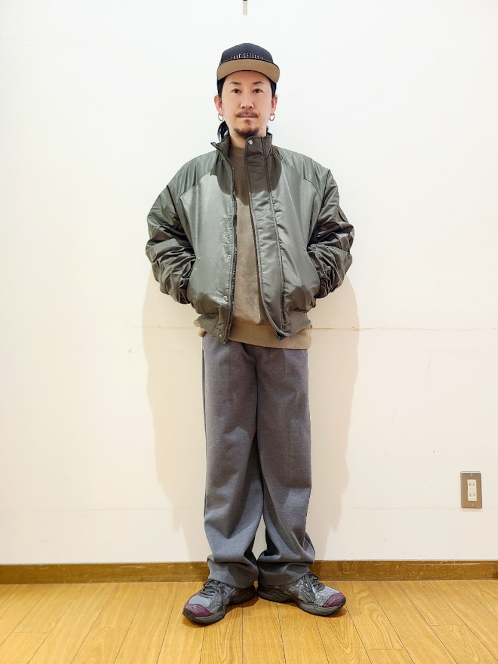 グリーン系のスウェット、グレー系のその他パンツ、ブラック系のキャップを着用したメンズの冬コーディネートの1枚目の写真