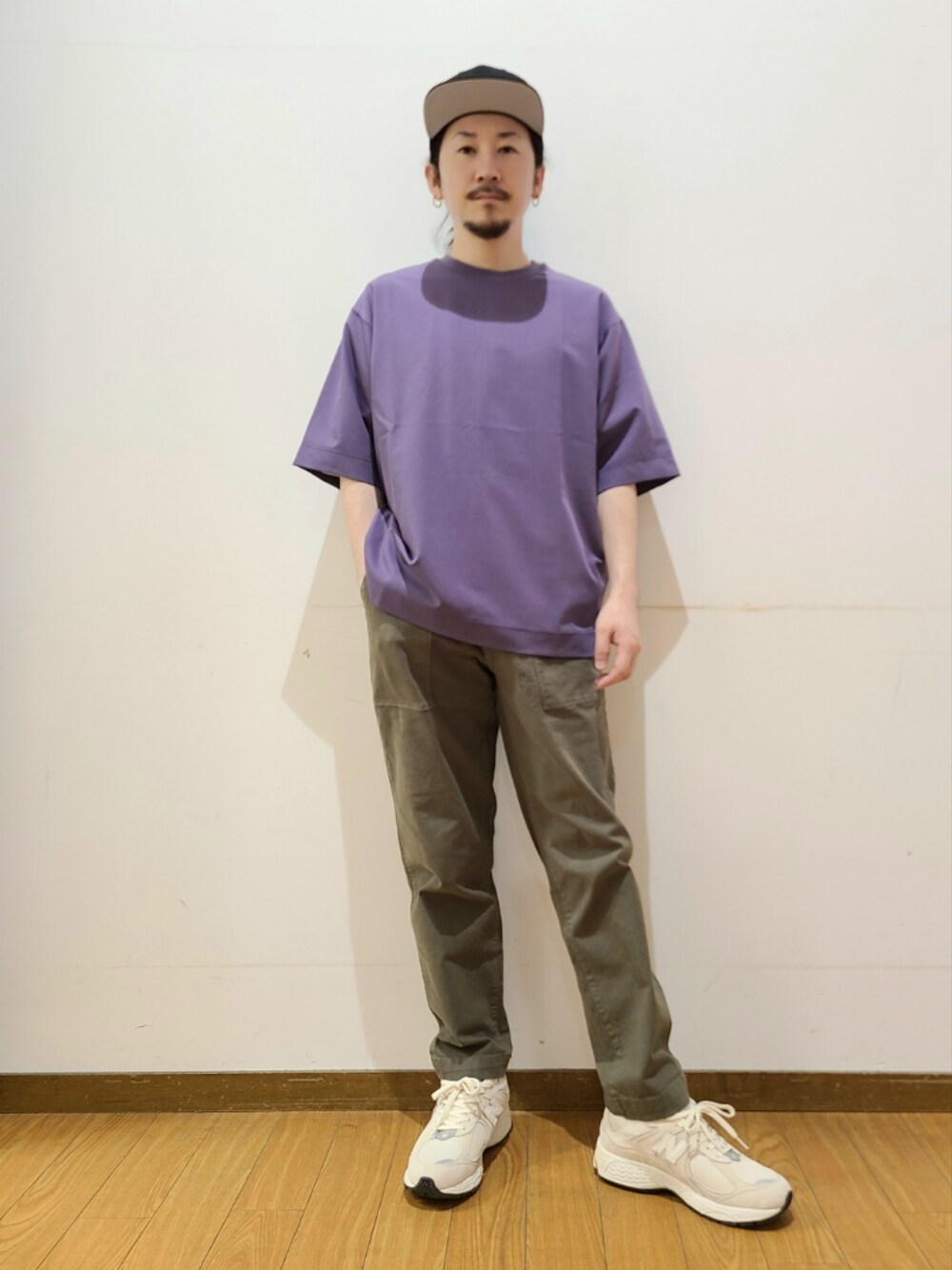 パープル系のTシャツ/カットソー、グリーン系のその他パンツ、ブラック系のキャップを着用したメンズの春コーディネートの1枚目の写真