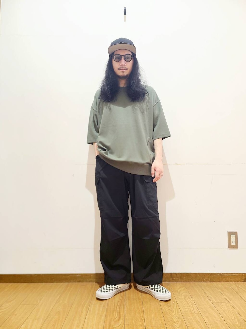 ブラック系のスニーカー、ブラック系のその他パンツ、グリーン系のTシャツ/カットソーを着用したメンズの春コーディネートの1枚目の写真