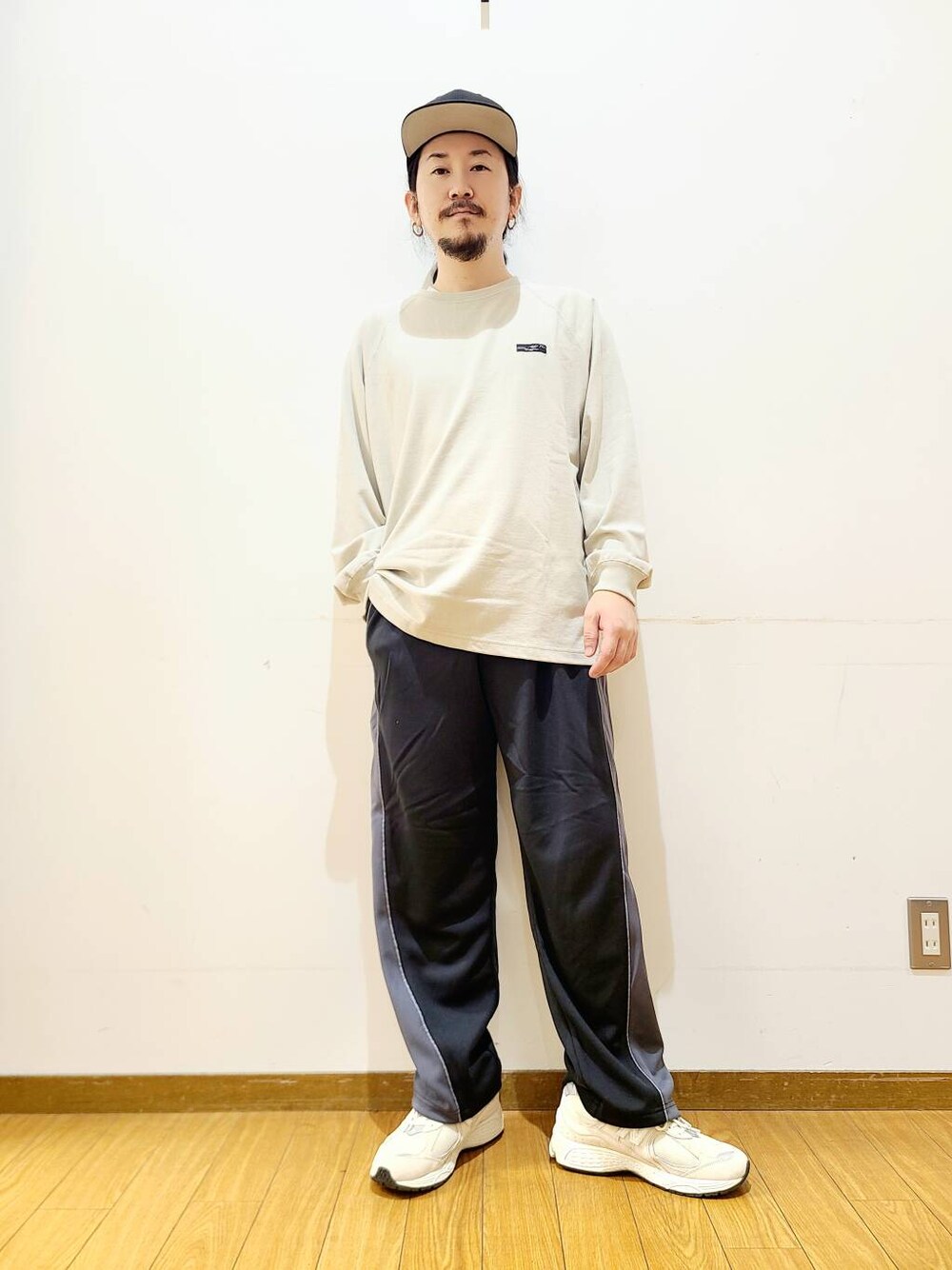 ベージュ系のTシャツ/カットソー、ブラック系のその他パンツを着用したメンズの秋コーディネートの1枚目の写真