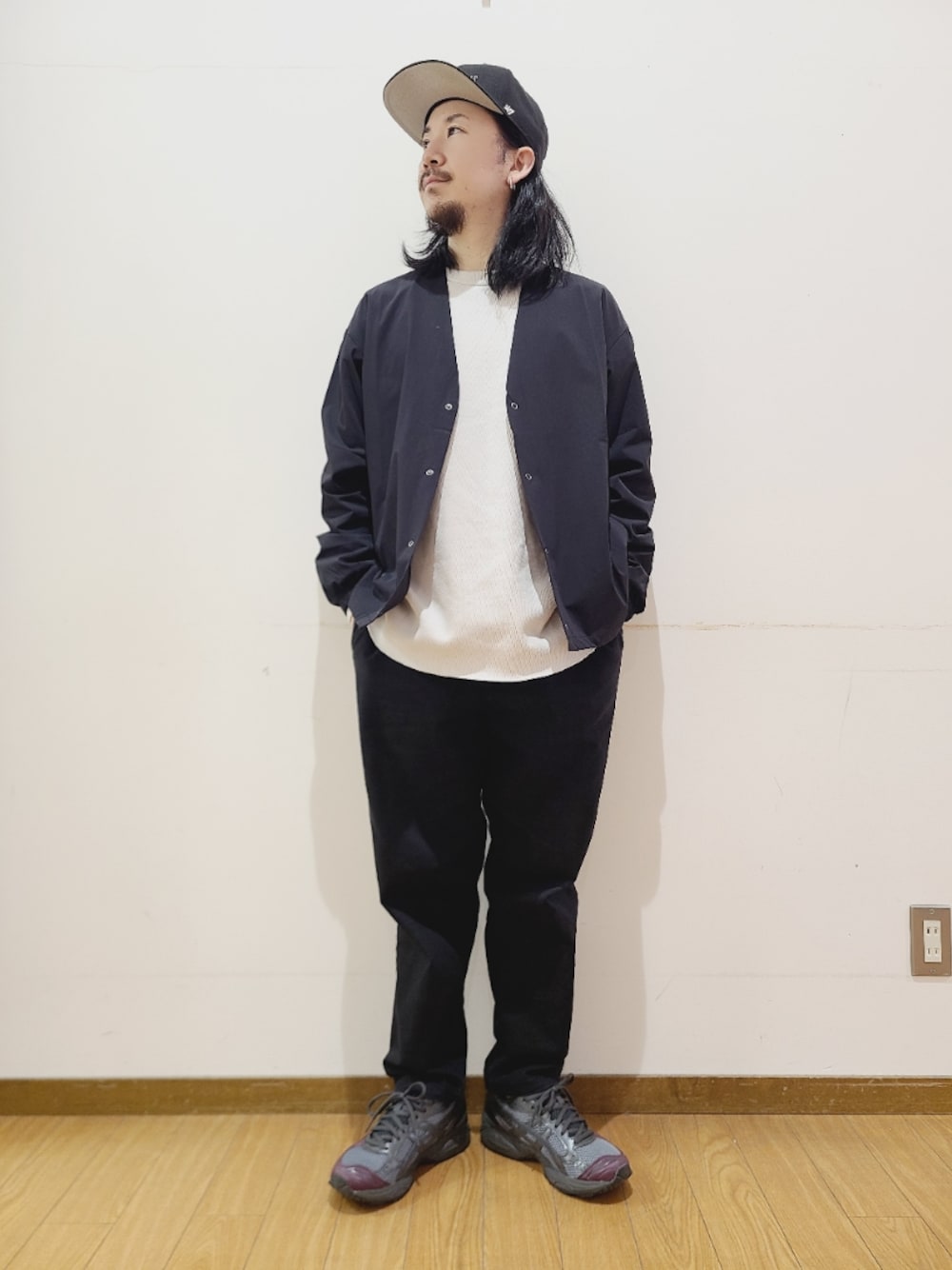 ブラック系のその他アウター、ブラック系のその他パンツ、ブラック系のキャップを着用したメンズの冬コーディネートの1枚目の写真