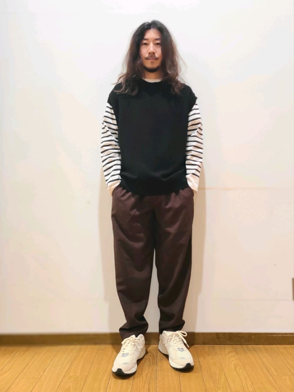 ブラック系のベスト、ブラック系のTシャツ/カットソー、ブラウン系のその他パンツを着用したメンズの春コーディネートの1枚目の写真