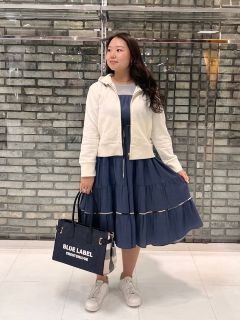 ブルー系のワンピース、ホワイト系のパーカーを着用したレディースの夏コーディネートの1枚目の写真