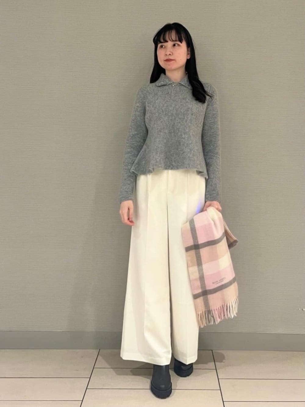 ブラック系のブーツ、シルバー系のボストンバッグ、グレー系のニット/セーターを着用したレディースの秋コーディネートの1枚目の写真