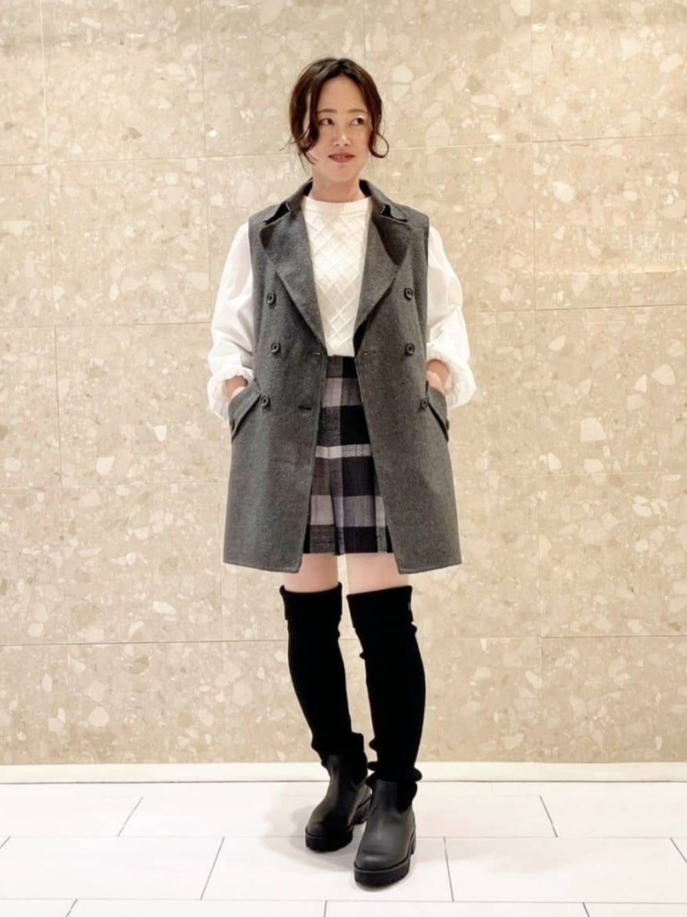 ホワイト系のニット/セーター、ブラック系のブーツ、ブラック系のその他パンツを着用したレディースの秋コーディネートの1枚目の写真