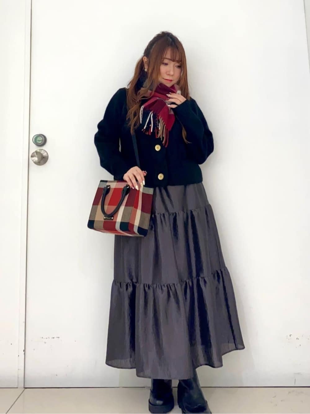 ブラック系のブーツ、レッド系のトートバッグ、ブラック系のスカートを着用したレディースの冬コーディネートの1枚目の写真