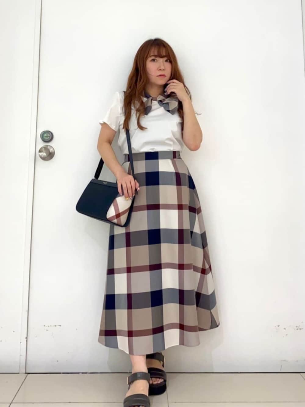 ホワイト系のTシャツ/カットソー、ベージュ系のスカートを着用したレディースの秋コーディネートの1枚目の写真