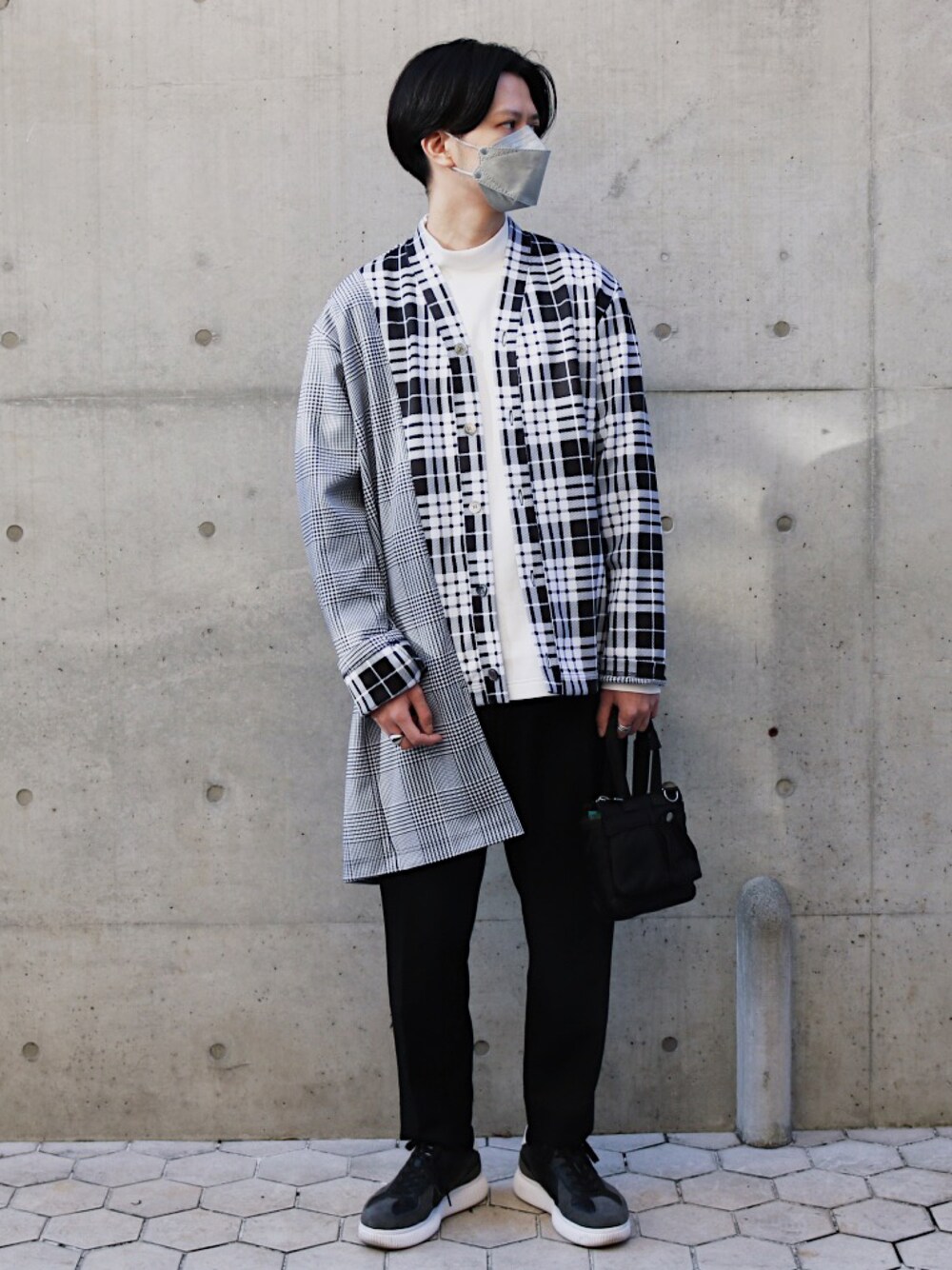 ブラック系のショルダーバッグ、ブラック系のスラックス、ブラック系のスニーカーを着用したメンズの秋コーディネートの1枚目の写真