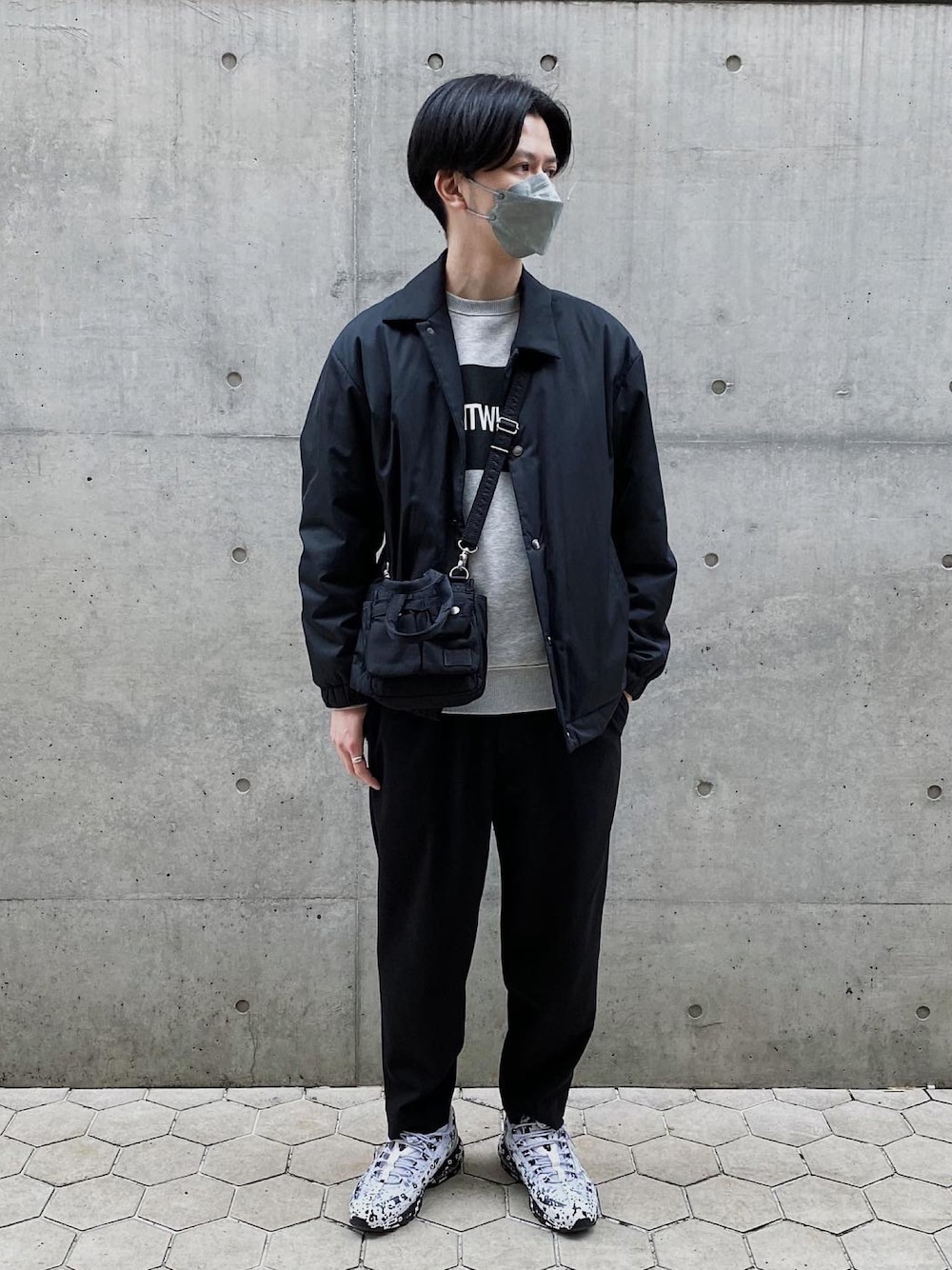 グレー系のスウェット、ブラック系のブルゾン、ブラック系のショルダーバッグを着用したメンズの春コーディネートの1枚目の写真