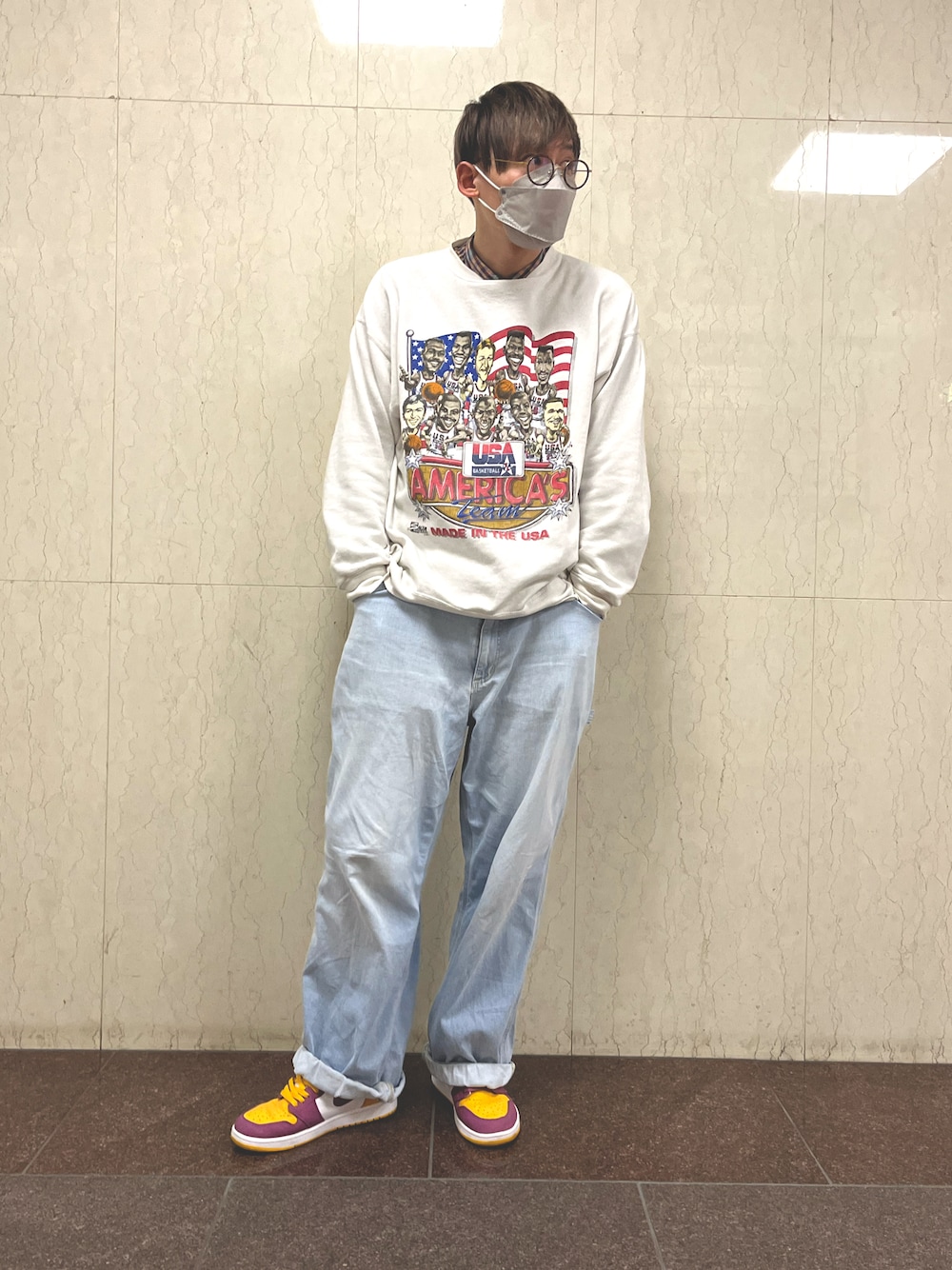 ブルー系のデニムパンツ、イエロー系のスニーカー、ホワイト系のスウェットを着用したメンズの冬コーディネートの1枚目の写真