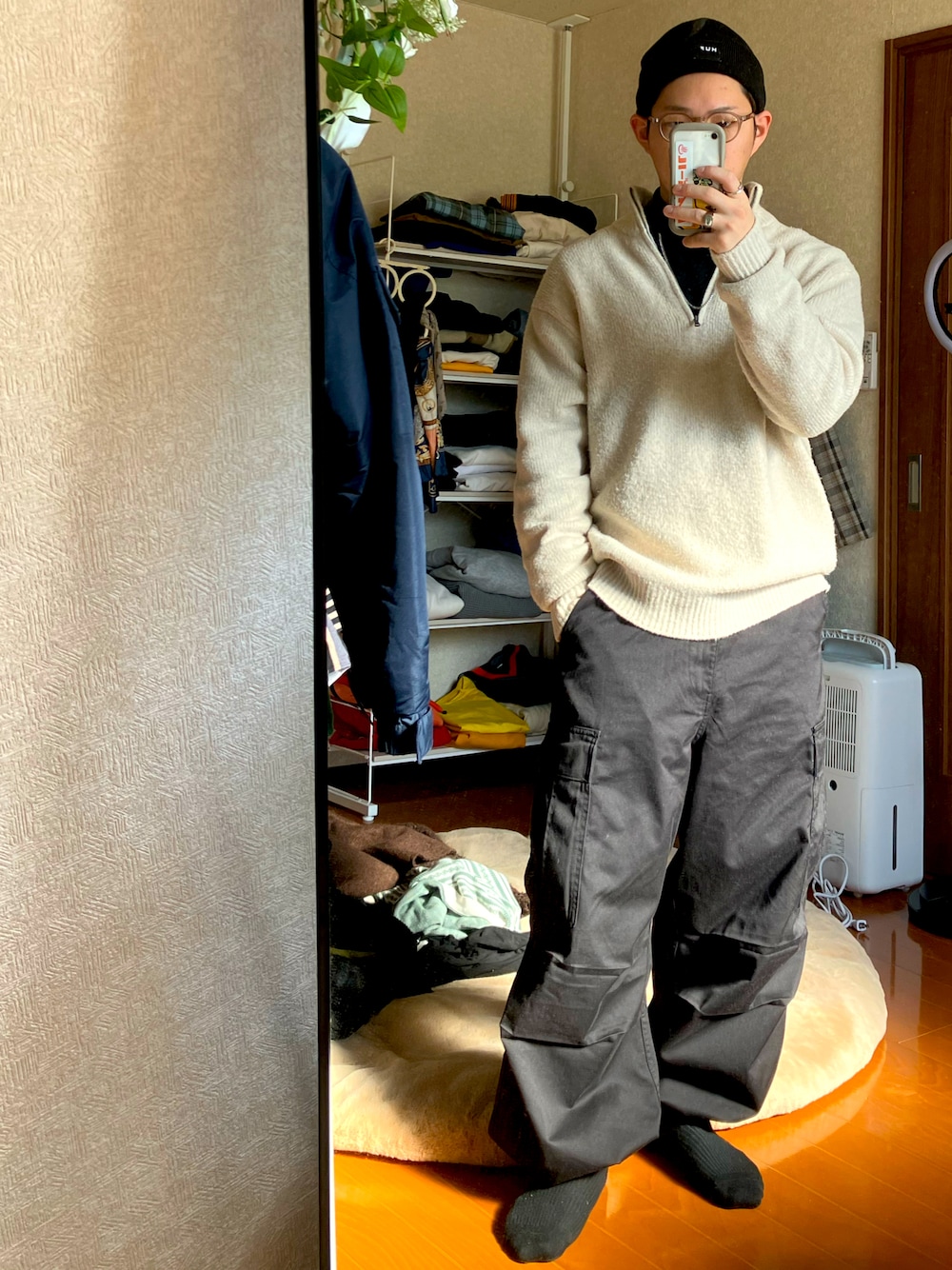 ブラック系のTシャツ/カットソー、ホワイト系のニット/セーター、ブラック系のカーゴパンツを着用したメンズの秋コーディネートの1枚目の写真