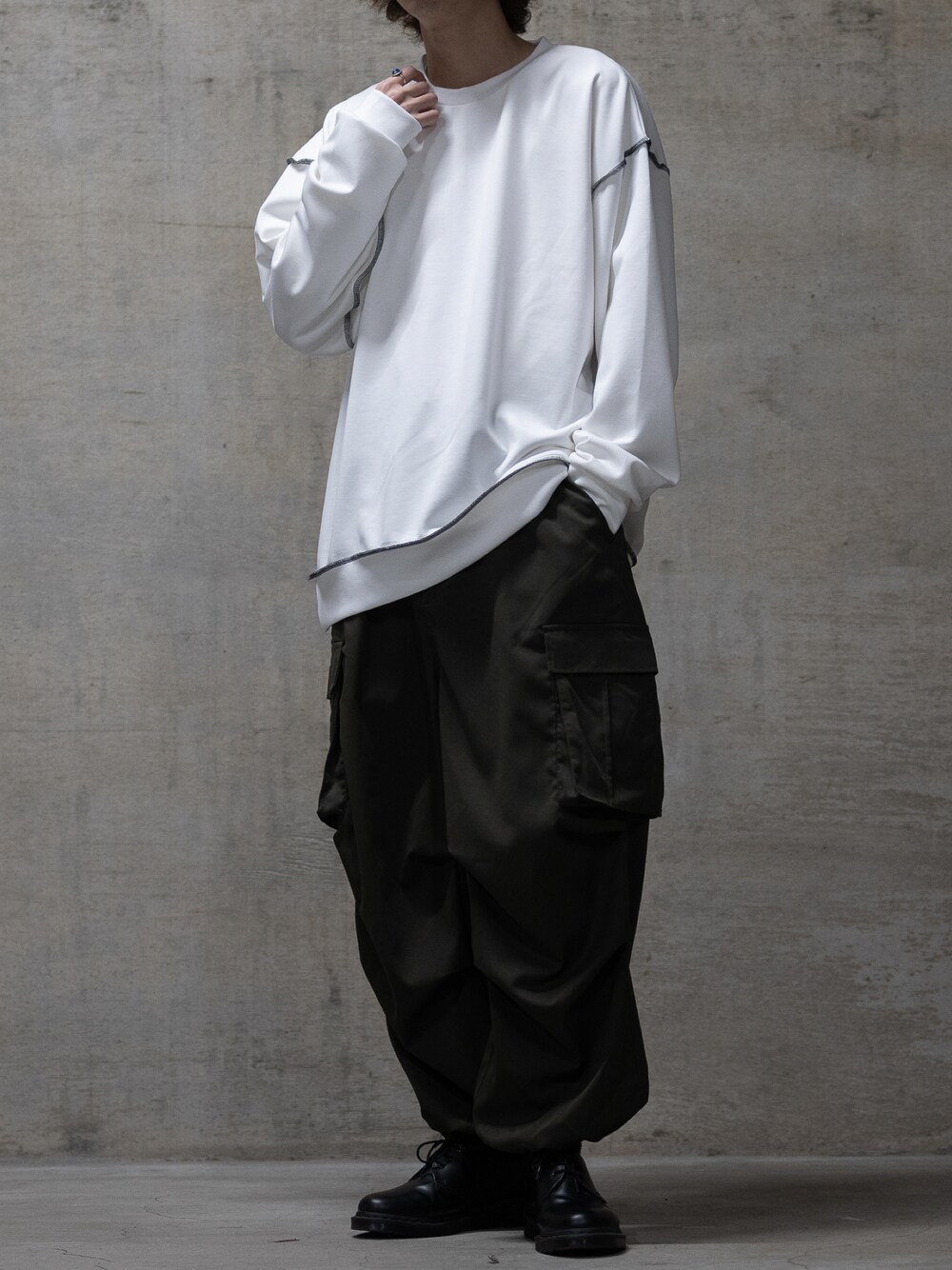 ブラック系のブーツ、グリーン系のカーゴパンツ、ホワイト系のスウェットを着用したメンズの冬コーディネートの1枚目の写真