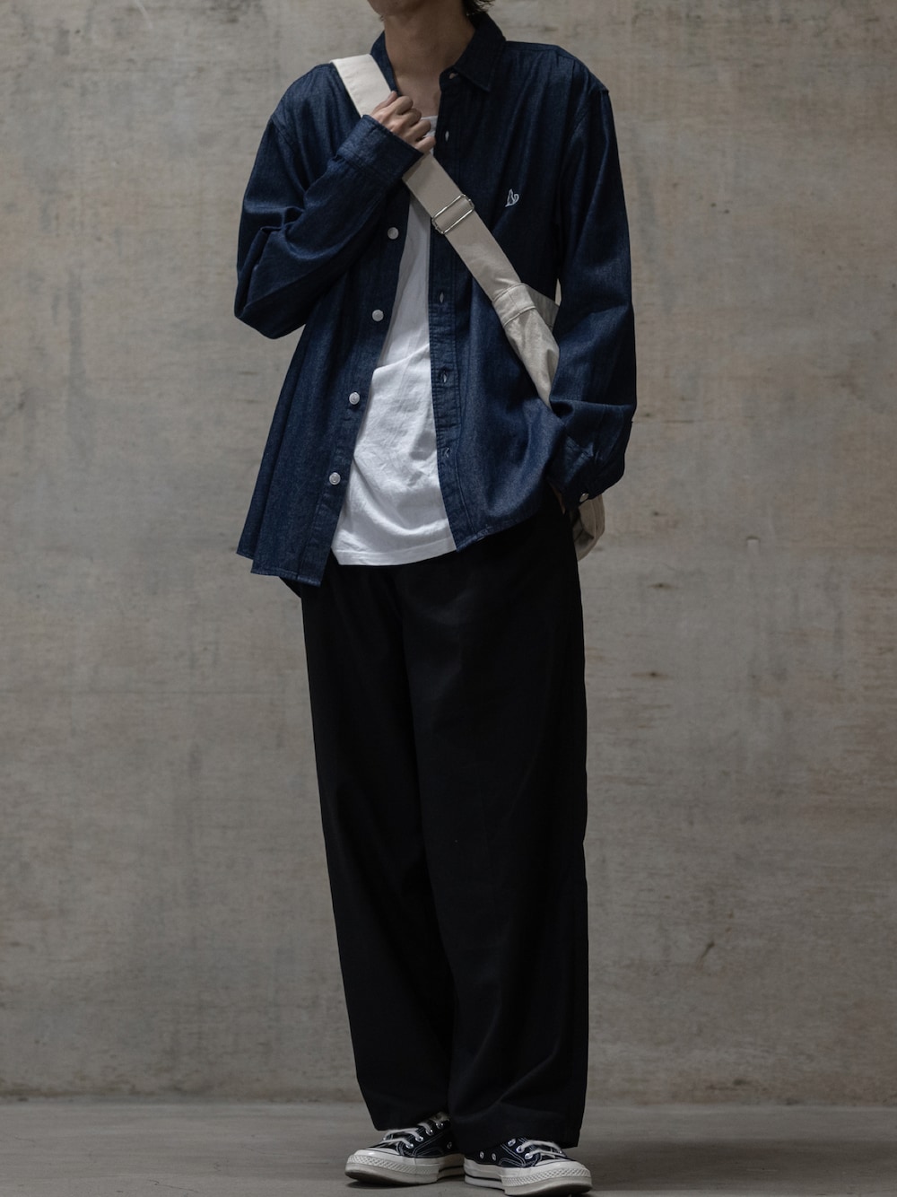 ブラック系のスラックス、ブラック系のスニーカー、ブルー系のシャツ/ブラウスを着用したメンズの秋コーディネートの1枚目の写真