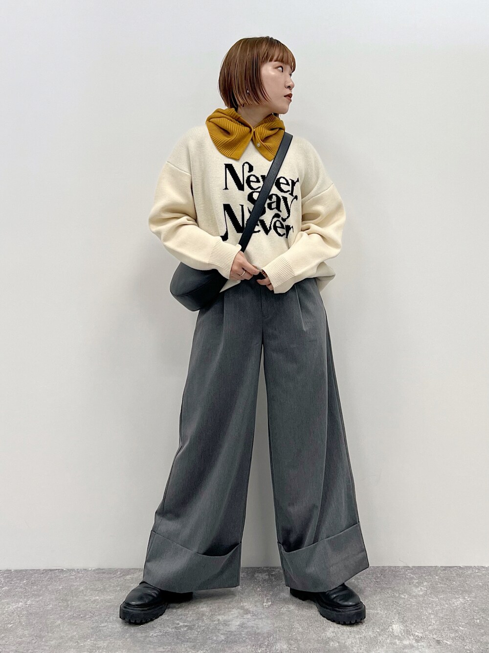 ベージュ系のニット/セーター、グレー系のスラックス、ブラック系のブーツを着用したレディースの秋コーディネートの1枚目の写真