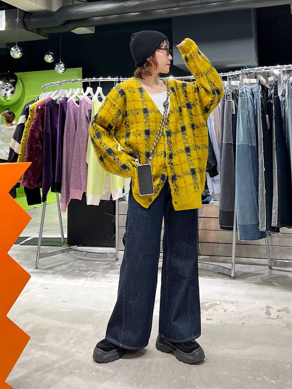 ブルー系のデニムパンツ、イエロー系のカーディガン/ボレロ、ブラック系のニットキャップ/ビーニーを着用したレディースの夏コーディネートの1枚目の写真