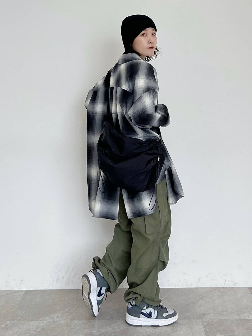 ブラック系のシャツ/ブラウス、ブラック系のショルダーバッグ、グリーン系のカーゴパンツを着用したレディースの秋コーディネートの1枚目の写真