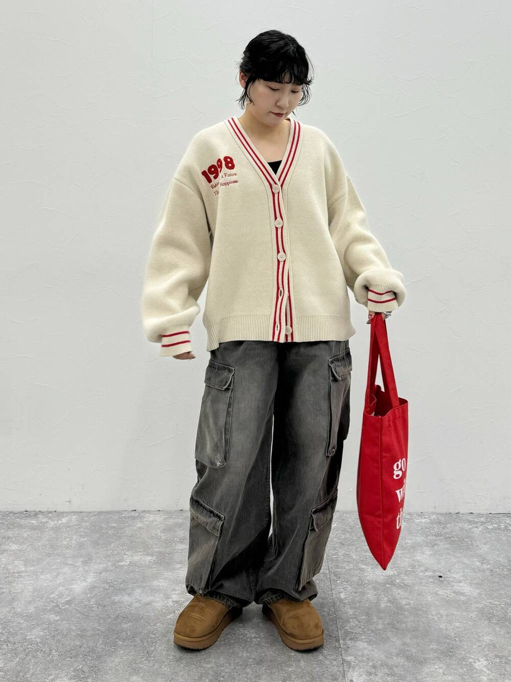 ブラック系のデニムパンツ、ベージュ系のカーディガン/ボレロを着用したレディースの秋コーディネートの1枚目の写真