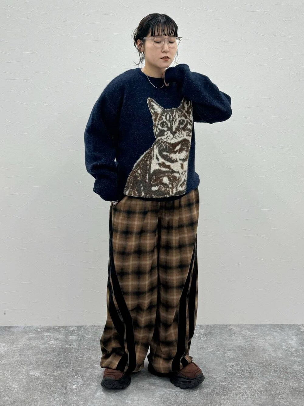 ブラウン系のローファー、ブラウン系のスラックス、ブルー系のニット/セーターを着用したレディースの秋コーディネートの1枚目の写真