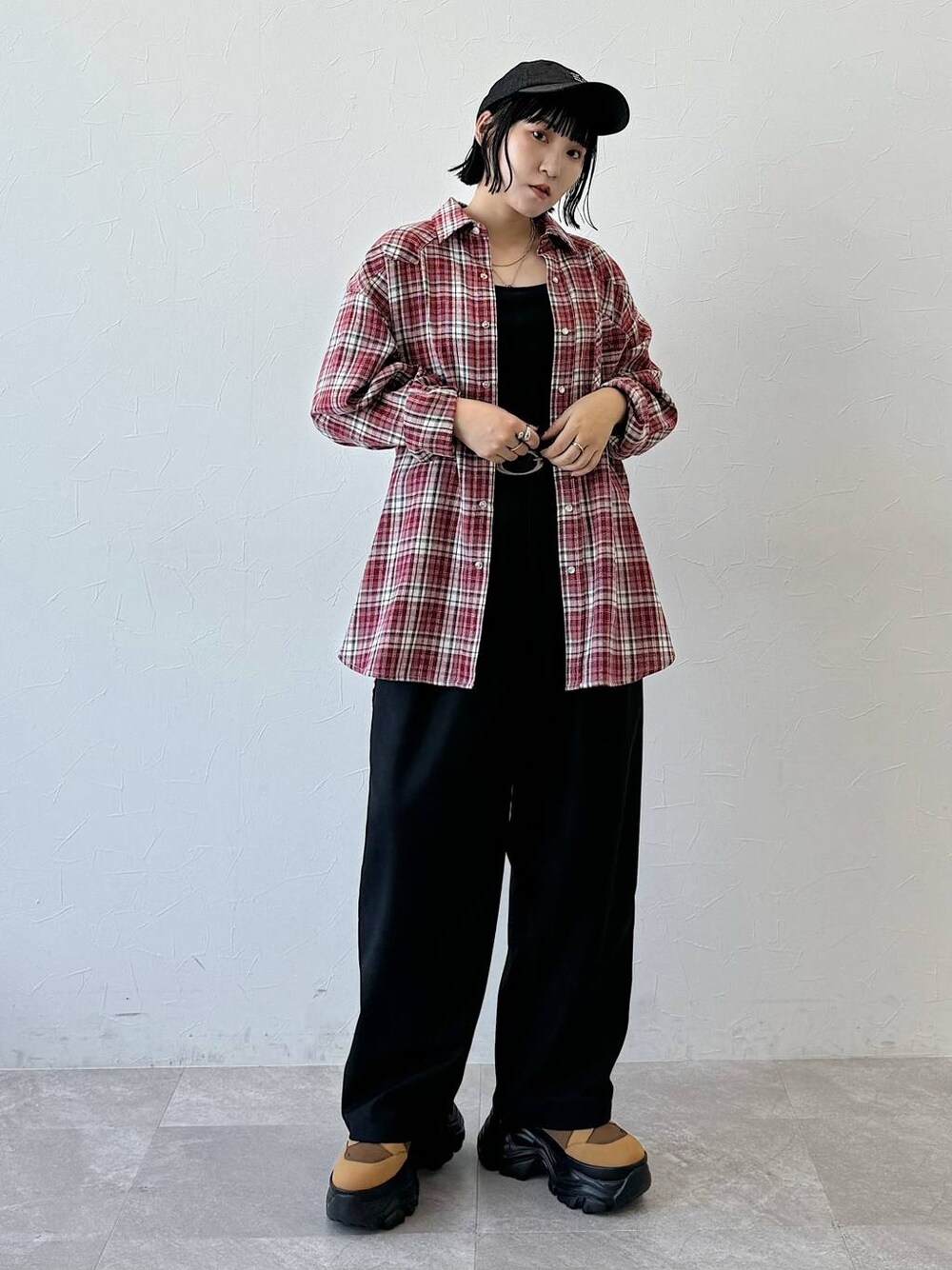 レッド系のシャツ/ブラウス、ブラック系のスラックスを着用したレディースの夏コーディネートの1枚目の写真