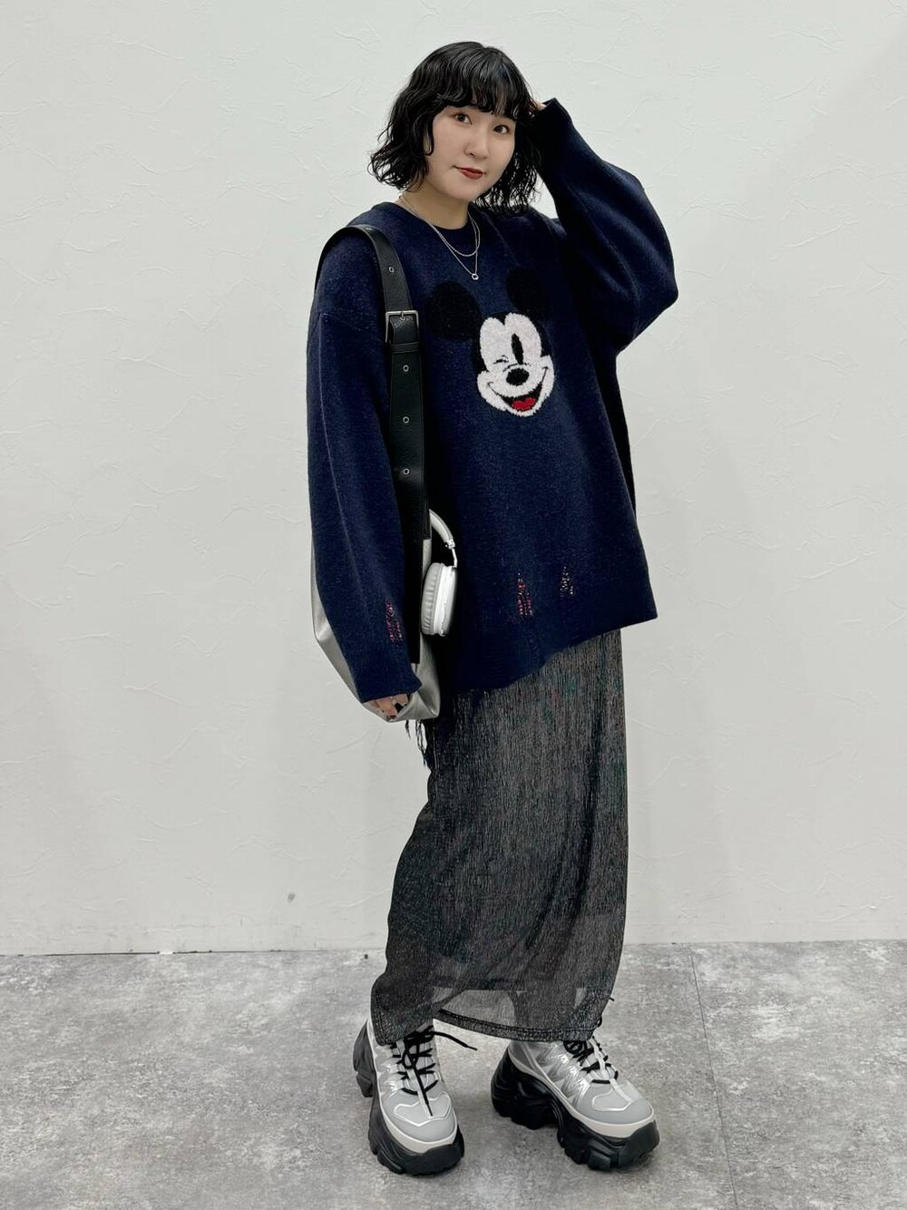 グレー系のスニーカー、シルバー系のトートバッグ、ブラック系のスカートを着用したレディースの秋コーディネートの1枚目の写真