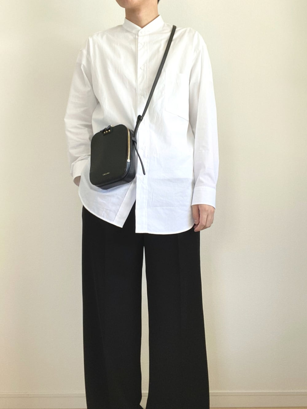 ブラック系のスラックス、ホワイト系のシャツ/ブラウス、ブラック系のショルダーバッグを着用したメンズの秋コーディネートの1枚目の写真