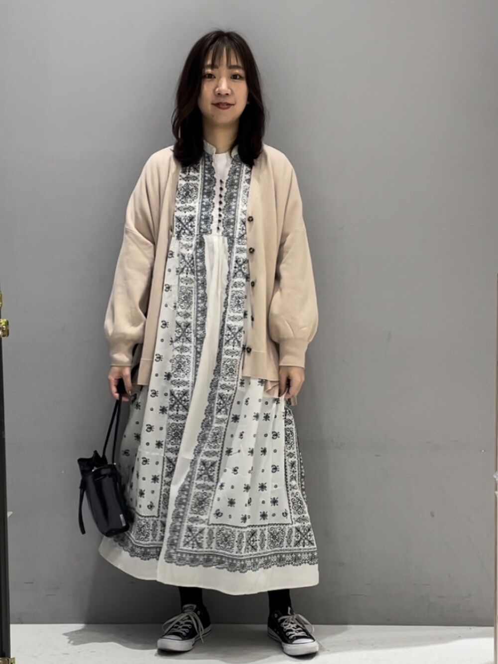 ベージュ系のワンピース、ベージュ系のカーディガン/ボレロ、ブラック系のトートバッグを着用したレディースの春コーディネートの1枚目の写真