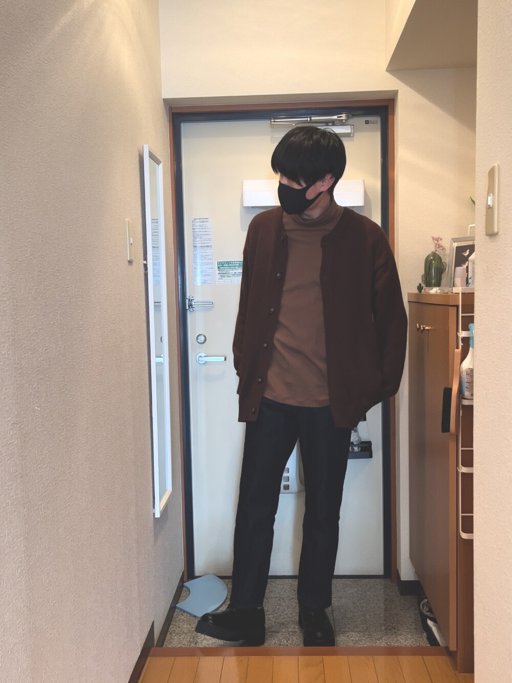 ブラウン系のカーディガン/ボレロ、ブラック系のデニムパンツ、ホワイト系のTシャツ/カットソーを着用したメンズの冬コーディネートの1枚目の写真