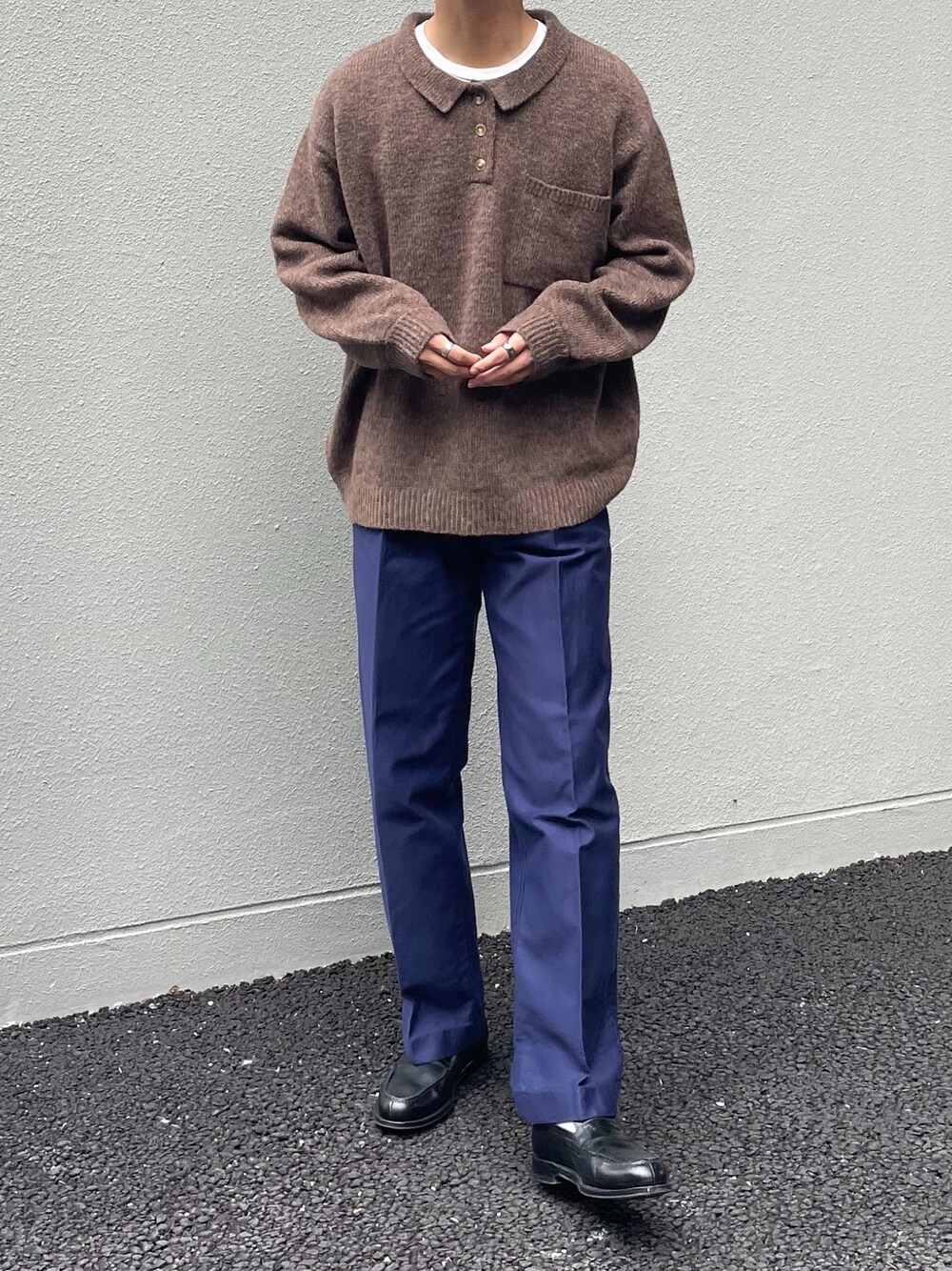 ブラウン系のニット/セーター、ブルー系のパンツ、ブラック系のローファーを着用したメンズの秋コーディネートの1枚目の写真